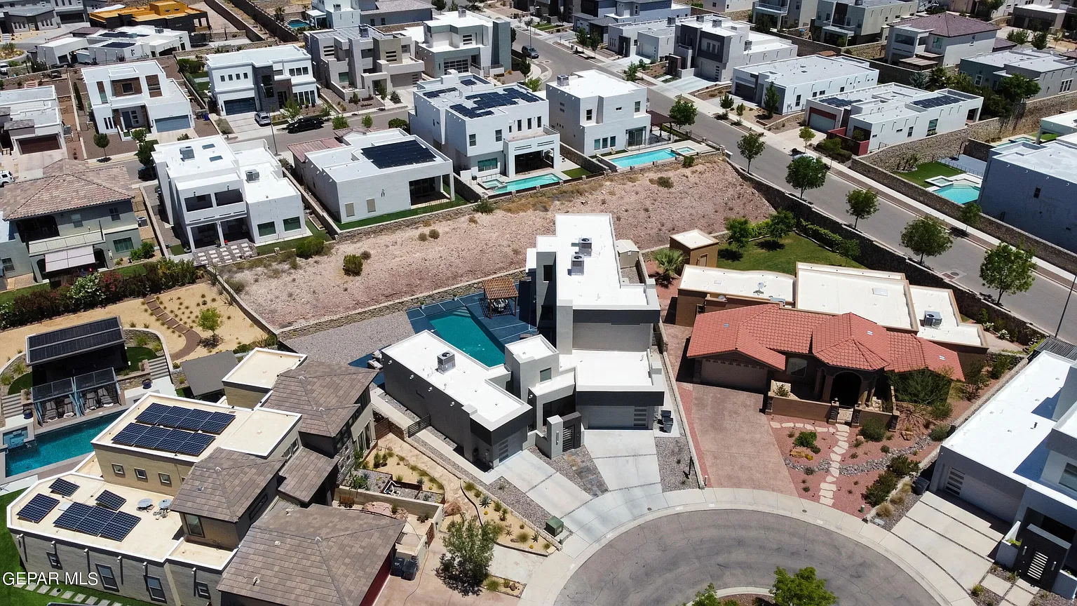 Original aerial photo of the modern hillside home and pool from the front-left of the cul-de-sac